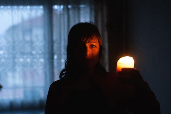 Woman Holding Candle in the Dark